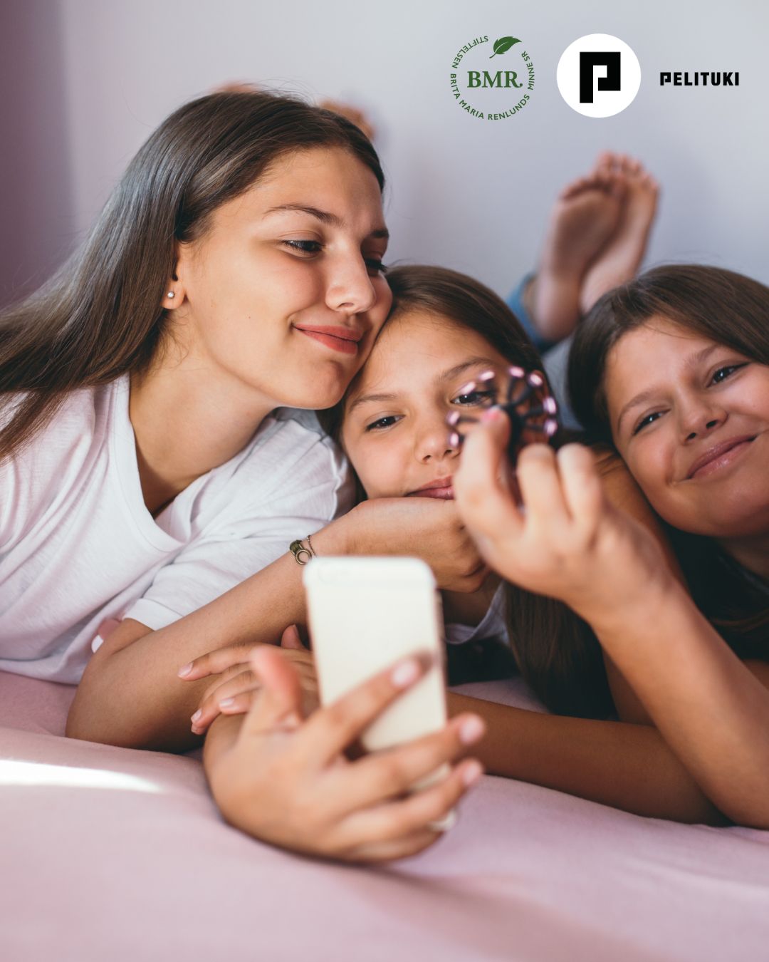 Föräldratips 26.8 Mobilförbud i skolan_ version 2 (2) Ungdomarna sitter bredid varandra och tittar tillsammans på mobilen.